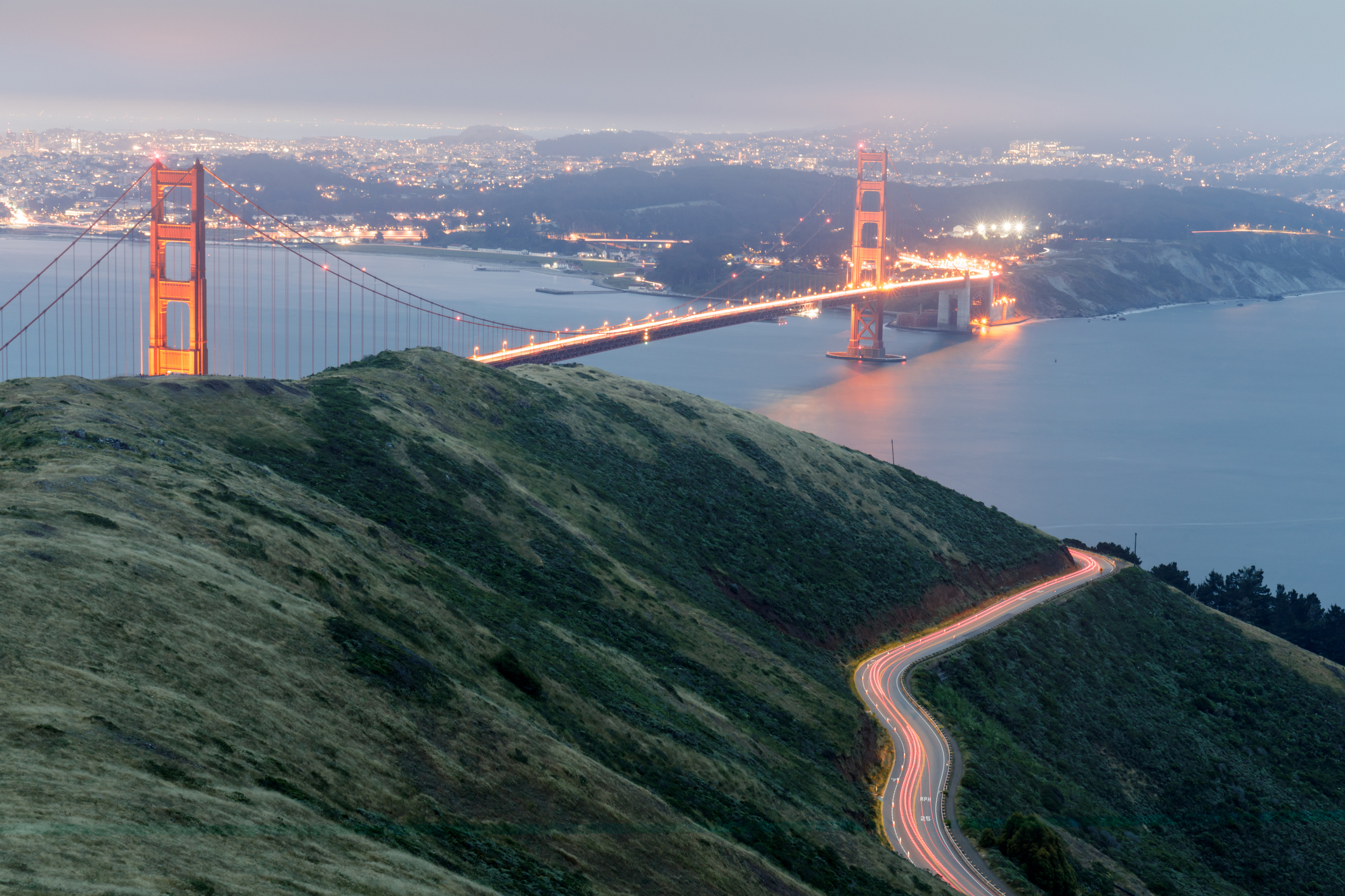 Golden Gate Bridge above the Bay Area coastline at dusk