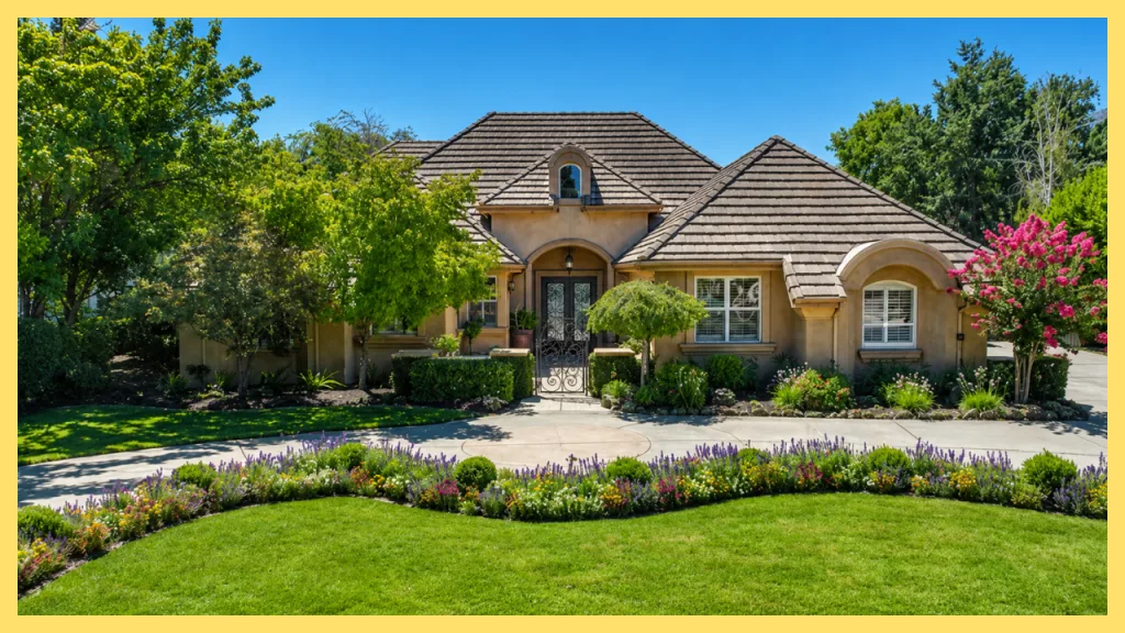 An elegant custom home in Folsom Lake Estates, Granite Bay, California, featuring a Mediterranean inspired exterior, tile roof, arched entryway, manicured landscaping, colorful flower beds, and mature shade trees. Set on a beautifully maintained lot, the property reflects the upscale character of Folsom Lake Estates, a highly desirable neighborhood known for luxury homes, spacious lots, and close proximity to Folsom Lake recreation.