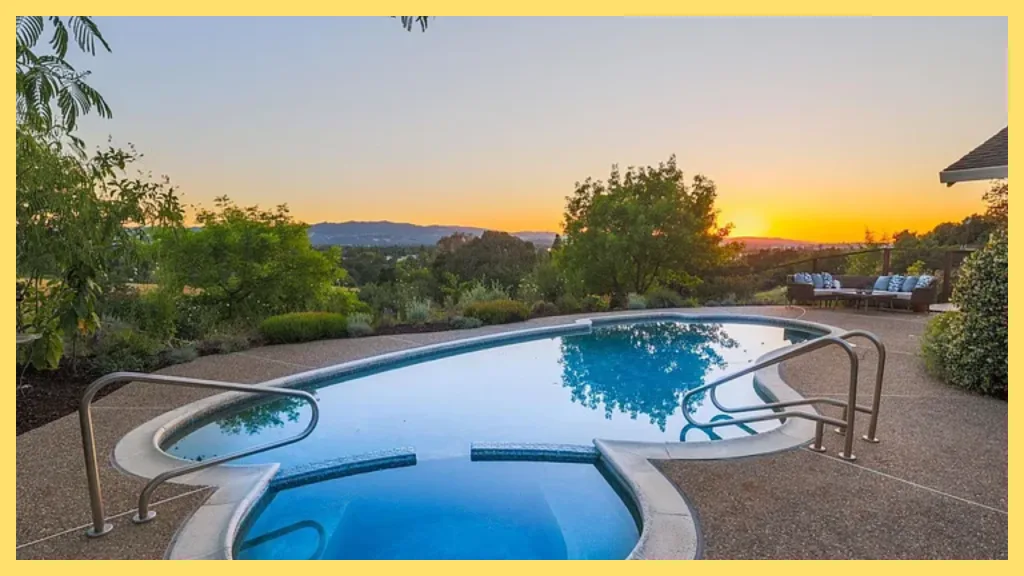 Luxury backyard with a swimming pool and spa overlooking rolling hills at sunset, surrounded by mature trees, landscaped gardens, and an outdoor seating area, illustrating the lifestyle goals of homeowners who use long term financing strategies to build their dream property over time.