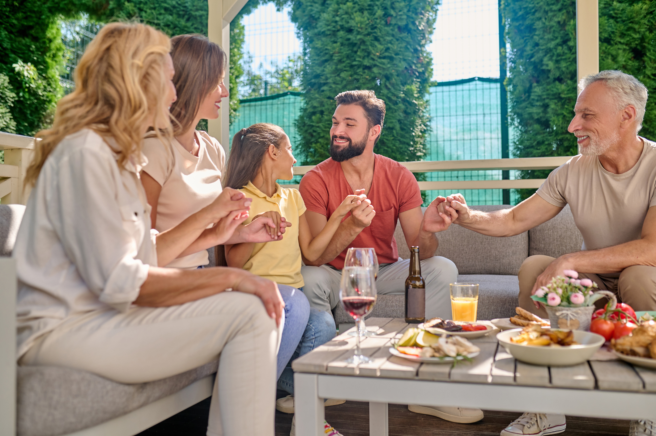 Three generations of a family sharing a meal together on a patio