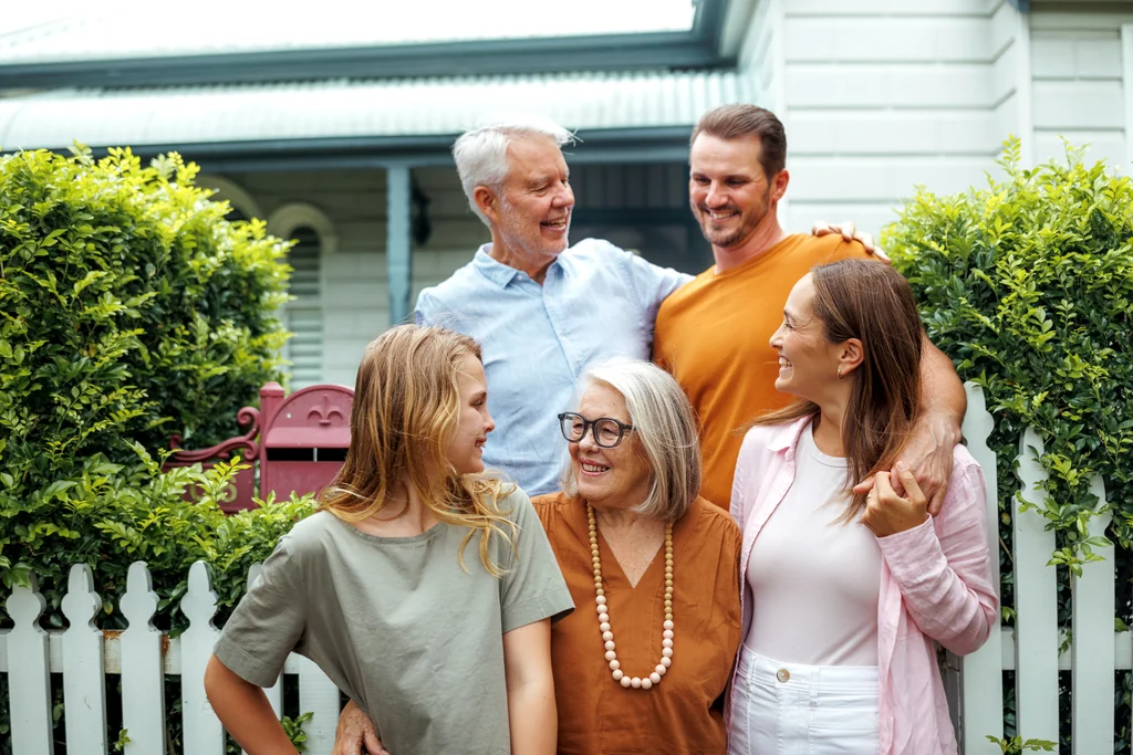 Three generations together outside a house